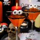 glass of citrus martini decorated with black sugar with marshmallow eyes on the table in honor of Halloween