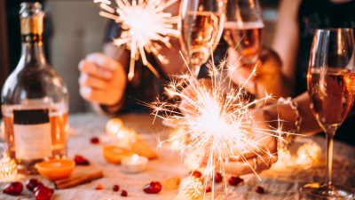 people gathered around table holding sparklers and wine glasses
