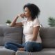 Anxious worried woman sitting on couch looking into the distance