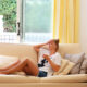 A woman sits on the couch suffering from a hangover